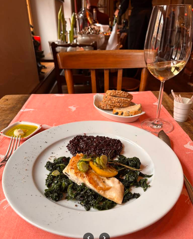 Frischer Fisch auf Spinatbett mit schwarzem Reis